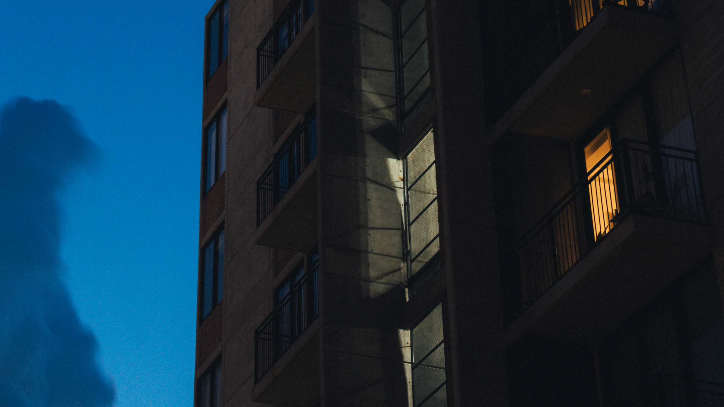 Edificio residencial contemporáneo iluminado al anochecer